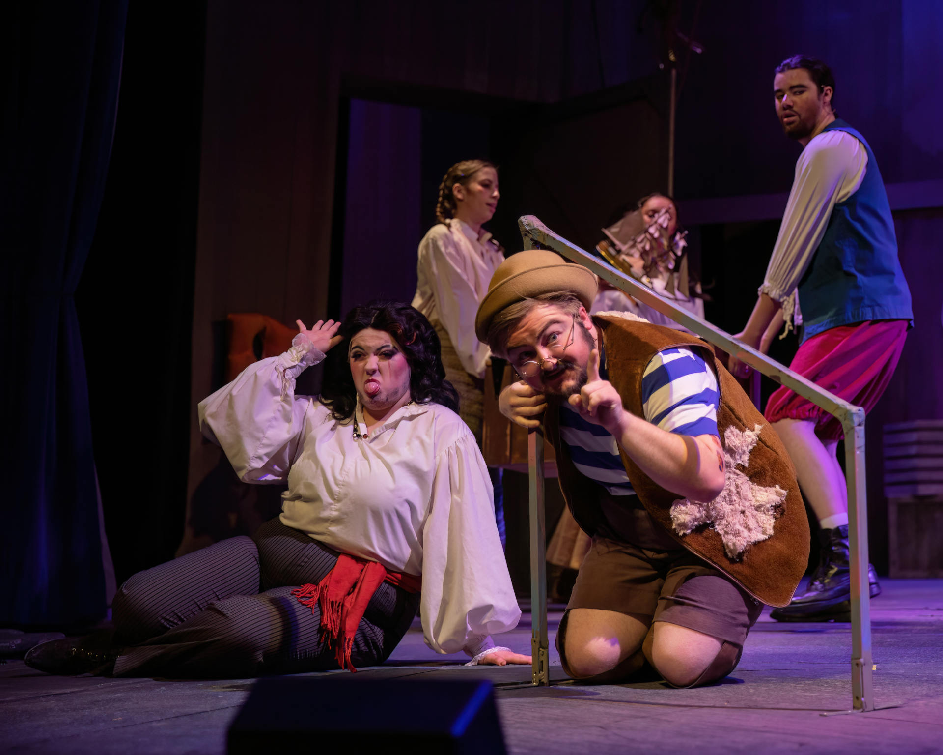 Characters Black Stache and Smee on a merry-go-round inset into the stage while a pirate crew carries a trunk behind them.