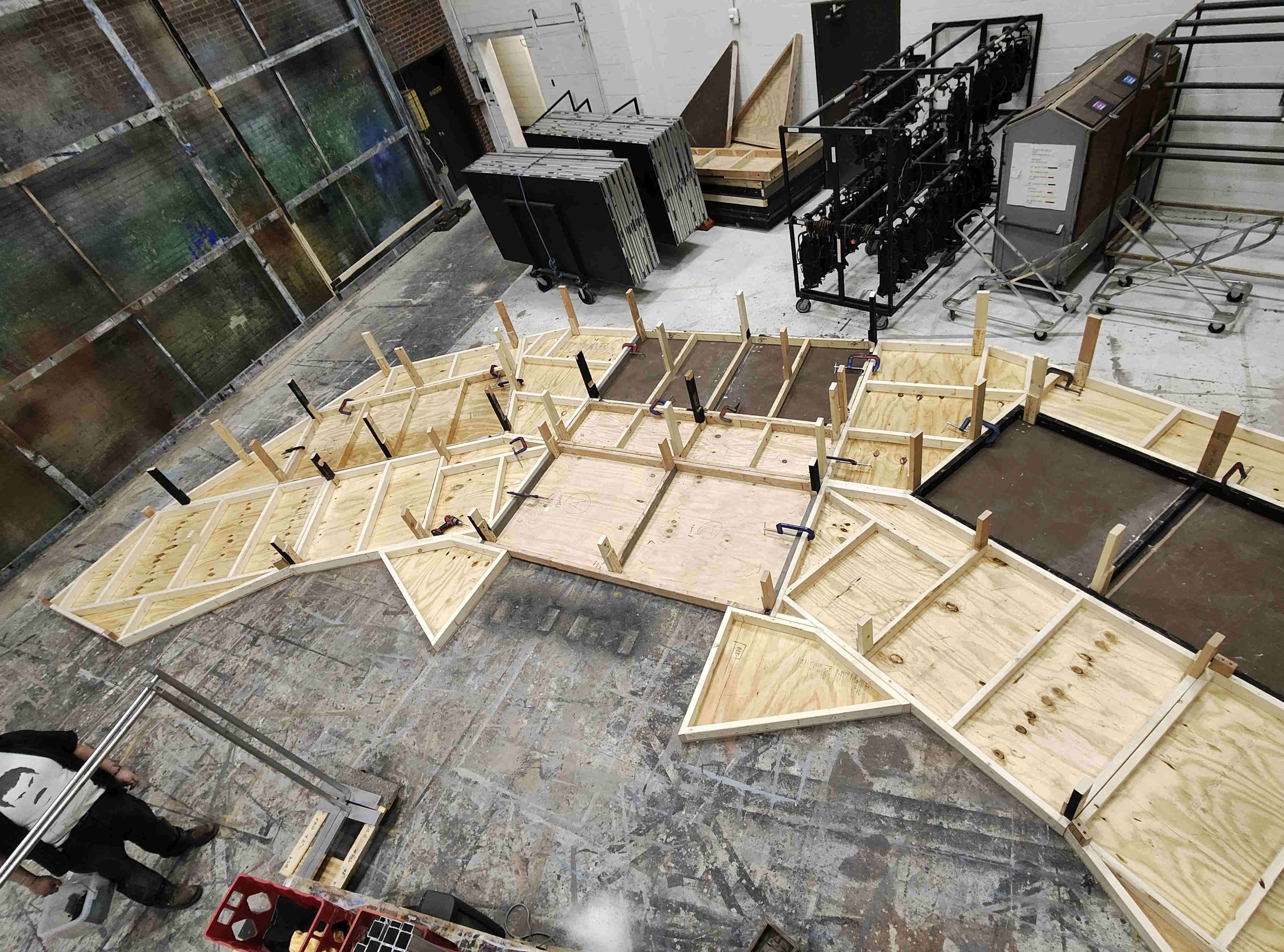 Angled wooden platforms flipped upside down in the shop to be bolted.